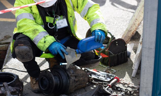 A Willow Pumps engineer adding oil to a sewage pump to maintain it and ensure it keeps working properly